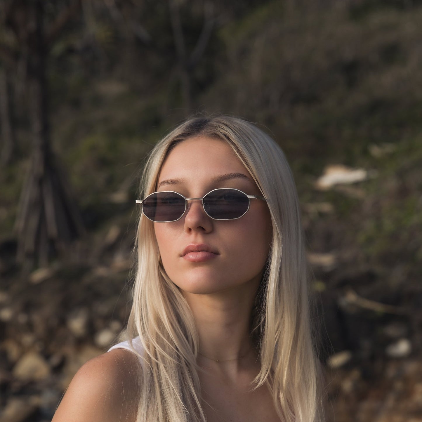 Woman wearing Alkira branded sunglasses with a natural background